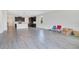 Open-concept living space with gray wood-look tile flooring, a kitchen with dark cabinets, and space for dining at 1504 Oak Marsh Loop, Davenport, FL 33837