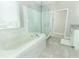 Spa-like bathroom featuring a soaking tub, glass shower, and sleek white cabinets at 15849 Sweet Lemon Way, Winter Garden, FL 34787