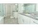 Bathroom featuring double vanities, granite countertops, white cabinetry, and a glass-enclosed shower at 15849 Sweet Lemon Way, Winter Garden, FL 34787