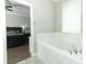 Bright bathroom featuring a soaking tub with marble surround and view into bedroom at 15849 Sweet Lemon Way, Winter Garden, FL 34787