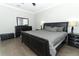 Bedroom with a padded headboard bed, side tables, dresser, and a black leather ottoman at 15849 Sweet Lemon Way, Winter Garden, FL 34787