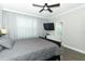 Bedroom featuring a dark padded headboard bed, TV, and ensuite bathroom with a soaking tub at 15849 Sweet Lemon Way, Winter Garden, FL 34787