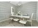 Bright dining room showcases a modern chandelier, stylish wallpaper, and elegant white table with clear chairs at 15849 Sweet Lemon Way, Winter Garden, FL 34787