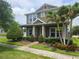 Charming two-story home featuring a landscaped front yard, inviting porch, and beautiful palm trees at 15849 Sweet Lemon Way, Winter Garden, FL 34787