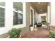Inviting front porch with brick flooring, columns, and a cozy seating area at 15849 Sweet Lemon Way, Winter Garden, FL 34787