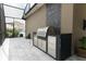 Outdoor kitchen boasts a stainless steel grill and sleek black countertops, perfect for outdoor cooking at 15849 Sweet Lemon Way, Winter Garden, FL 34787