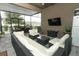 Relax in this outdoor screened-in patio that includes furniture and a TV for entertainment at 15849 Sweet Lemon Way, Winter Garden, FL 34787