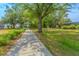 Scenic backyard featuring a long pathway and beautiful, mature trees at 1598 Whitewood Ct, Kissimmee, FL 34747