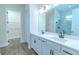 Bright bathroom with dual vanity sinks, a glass enclosed shower, and wood-look floors at 1598 Whitewood Ct, Kissimmee, FL 34747
