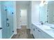 Bright bathroom with dual vanity sinks, a glass enclosed shower, and wood-look floors at 1598 Whitewood Ct, Kissimmee, FL 34747