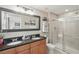 Modern bathroom with double sinks, granite countertops, a glass-enclosed shower, and stylish fixtures at 16163 Pebble Bluff Loop, Winter Garden, FL 34787