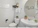 Well-lit powder room featuring a modern vanity, decorative mirror, and stylish wall decor at 16163 Pebble Bluff Loop, Winter Garden, FL 34787
