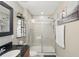 Bathroom featuring a glass enclosed shower, black granite countertop, and decorative art at 16163 Pebble Bluff Loop, Winter Garden, FL 34787
