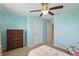 Bright bedroom with blue walls, a ceiling fan, and a wooden dresser at 16163 Pebble Bluff Loop, Winter Garden, FL 34787