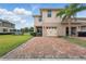 Paver driveway leading to a two-car garage in a well-maintained community at 16163 Pebble Bluff Loop, Winter Garden, FL 34787