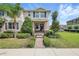 Charming two-story townhome featuring manicured landscaping and a welcoming entrance with a brick walkway and cozy seating at 16163 Pebble Bluff Loop, Winter Garden, FL 34787
