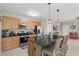 Cozy kitchen featuring stainless steel appliances, wooden cabinets, and an island with barstool seating at 16163 Pebble Bluff Loop, Winter Garden, FL 34787