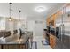 Open kitchen with large island, modern appliances, and stylish pendant lighting at 16163 Pebble Bluff Loop, Winter Garden, FL 34787