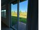 Backyard view from sliding glass door shows landscaped community and lush green grass at 16468 Happy Eagle Dr, Clermont, FL 34714