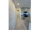 Long hallway leads to modern kitchen with stainless steel appliances and granite countertops at 16468 Happy Eagle Dr, Clermont, FL 34714