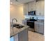 Close up view of kitchen with granite countertops, stainless appliances, and gray cabinets at 16468 Happy Eagle Dr, Clermont, FL 34714