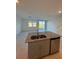 Modern kitchen flows into living area and features granite countertops and stainless steel appliances at 16468 Happy Eagle Dr, Clermont, FL 34714