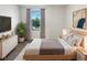 Bright bedroom features a large window, neutral decor, and sleek contemporary furniture at 16518 Brook Springs Aly, Winter Garden, FL 34787