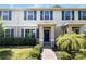 Inviting townhouse featuring a covered entryway, blue shutters and landscaping at 16518 Brook Springs Aly, Winter Garden, FL 34787