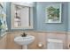 The charming bathroom features a pedestal sink, tiled walls, and classic fixtures at 1724 Cottonwood Creek Pl, Lake Mary, FL 32746