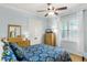 Cozy bedroom with a floral patterned bedspread, complemented by a dresser, mirror, and bright window at 1724 Cottonwood Creek Pl, Lake Mary, FL 32746