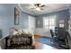Cozy bedroom with blue walls, hardwood floors, a decorative bookshelf, and a comfortable workspace at 1724 Cottonwood Creek Pl, Lake Mary, FL 32746