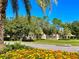 Picturesque entrance to Magnolia Plantation featuring beautiful landscaping, colorful flowers, and elegant signage at 1724 Cottonwood Creek Pl, Lake Mary, FL 32746