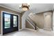 Inviting foyer featuring double doors, elegant chandelier, staircase, and neutral color palette at 1724 Cottonwood Creek Pl, Lake Mary, FL 32746
