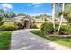 Charming yellow home with brick driveway, stone accents, mature landscaping, and a tile roof at 1724 Cottonwood Creek Pl, Lake Mary, FL 32746