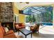 Cozy outdoor living space with fireplace, comfortable seating, and view of the screened-in pool at 1724 Cottonwood Creek Pl, Lake Mary, FL 32746
