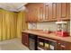Charming wet bar area with custom cabinetry, beverage refrigerator, and vintage-inspired decor at 1724 Cottonwood Creek Pl, Lake Mary, FL 32746