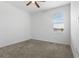 Comfortable bedroom with a ceiling fan, plush carpet, and ample natural light from a window at 1757 Brush Cherry Pl, Ocoee, FL 34761