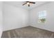Cozy bedroom with neutral carpet, ceiling fan, and a large window offering natural light at 1757 Brush Cherry Pl, Ocoee, FL 34761