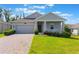 Charming one-story home featuring a well-manicured lawn and inviting covered front porch at 1757 Brush Cherry Pl, Ocoee, FL 34761