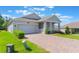 Well maintained, one-story home showcasing a brick paved driveway and manicured landscaping at 1757 Brush Cherry Pl, Ocoee, FL 34761