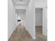 Hallway featuring wood-look floors and white trim leading to rooms with ceiling fans at 1757 Brush Cherry Pl, Ocoee, FL 34761