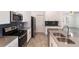Kitchen features modern stainless steel appliances, dark backsplash, and white cabinetry at 1757 Brush Cherry Pl, Ocoee, FL 34761