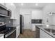 Open kitchen with stainless steel appliances, gray backsplash, and plenty of storage space at 1757 Brush Cherry Pl, Ocoee, FL 34761