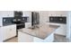 Beautiful kitchen island with stainless steel sink, gray countertops, and white cabinetry at 1757 Brush Cherry Pl, Ocoee, FL 34761