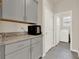 This laundry room includes appliances, granite countertops, and a gray storage at 17847 Adrift Rd, Winter Garden, FL 34787