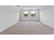 Large bedroom with neutral carpet and white walls and a pair of windows at 2055 Town Pasture Dr, Eustis, FL 32726