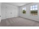 Bright bedroom with carpet, two windows providing natural light, and double door closet at 2055 Town Pasture Dr, Eustis, FL 32726