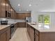 Modern kitchen features stainless steel appliances, tile backsplash, and a large island with quartz countertop at 2055 Town Pasture Dr, Eustis, FL 32726