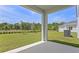 A covered patio with a view of the lush green lawn and a beautiful treeline at 2055 Town Pasture Dr, Eustis, FL 32726