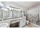Bright bathroom featuring double sinks, and floral patterned shower curtain at 206 E South St # 3008, Orlando, FL 32801